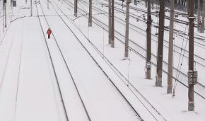 Работник железной дороги обходит железнодорожные пути