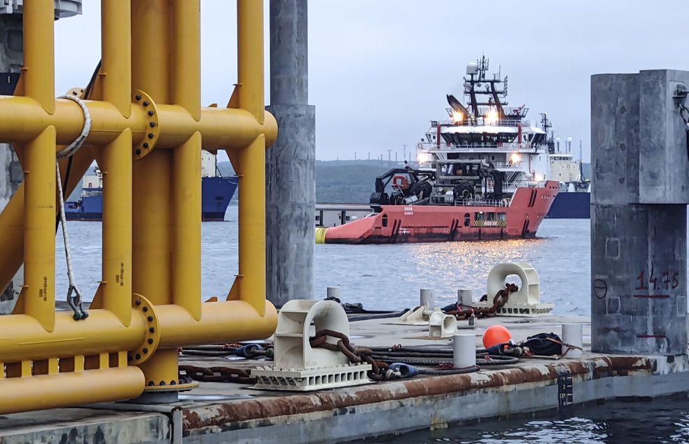 A tugboat tows the LNG production platform from the dry dock at the Novatek‒Murmansk LNG Construction Center