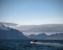 A ship sails past an island of the Svalbard archipelago, Norway