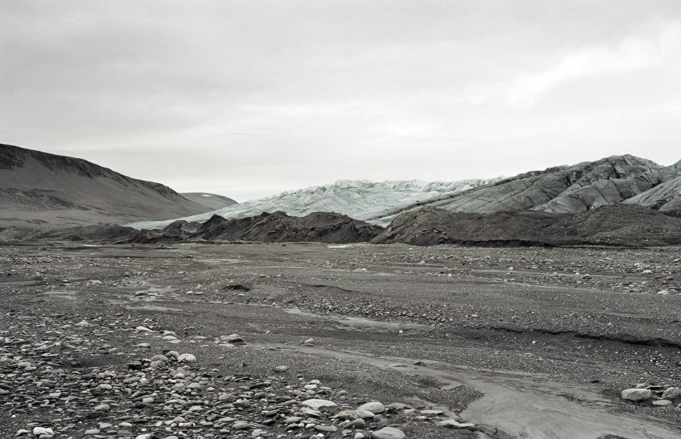 Waste banks with fragmented slate in front of Blue Glacier. Og Bay