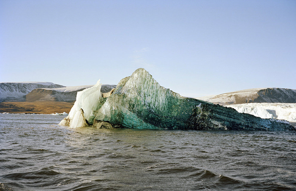An iceberg that flipped over. Its bottom part has a blue tint from the sea