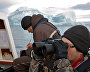 Expedition members Dmitry Moseyev and Yevgeny Kuzmin aboard the yacht monitor the island coastal zone