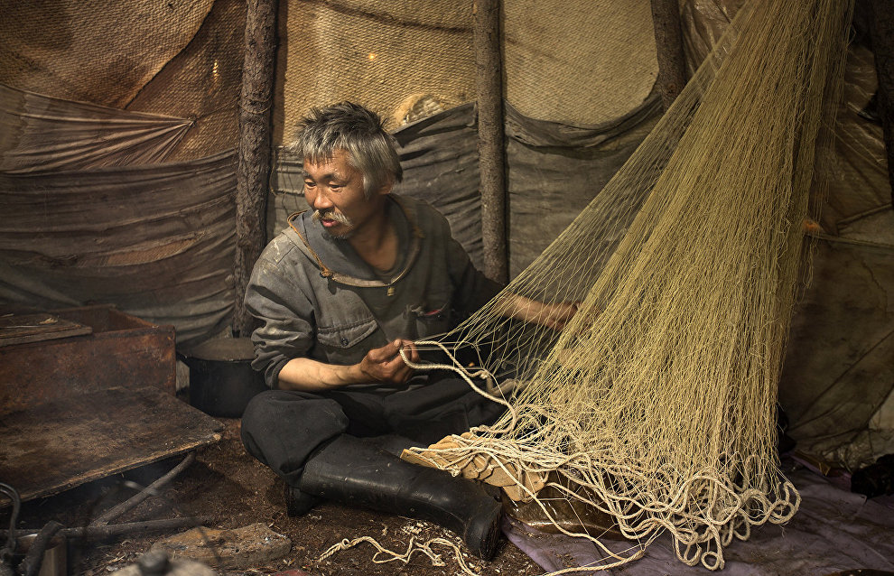 An Evenki fisher sorting the nets. Lake Khantaiskoye, Putorana Plateau