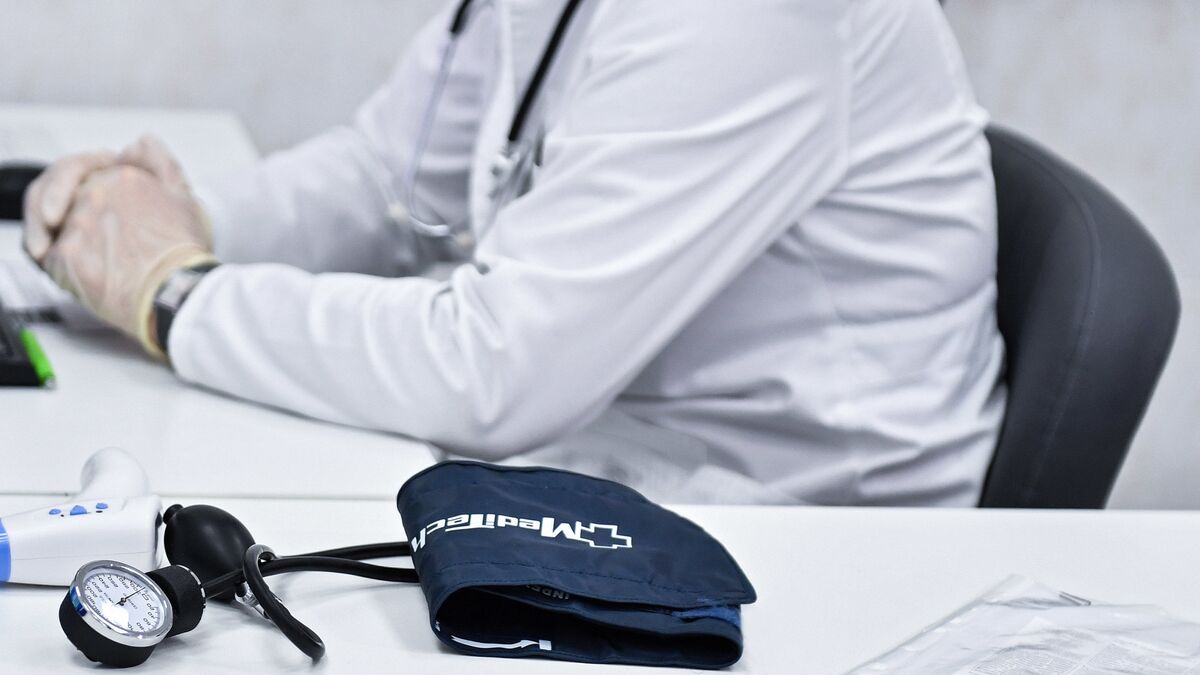 Врач сидит за столом в кабинете