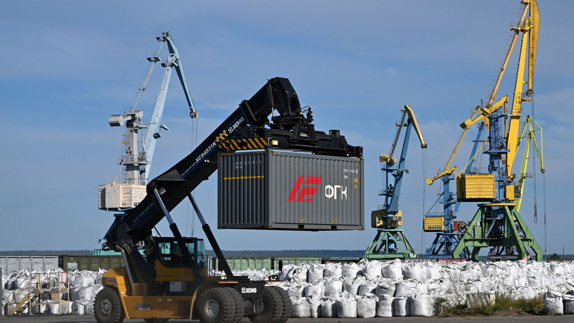 Автопогрузчик в порту перевозит контейнер для дальнейшей транспортировки в рамках северного завоза - РИА Новости, 1920, 21.01.2026